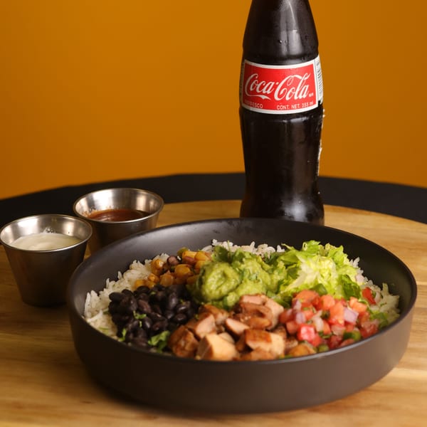 Bueno Burrito bowl with chicken, rice, beans, corn, guacamole, salsa, and a Coca-Cola.